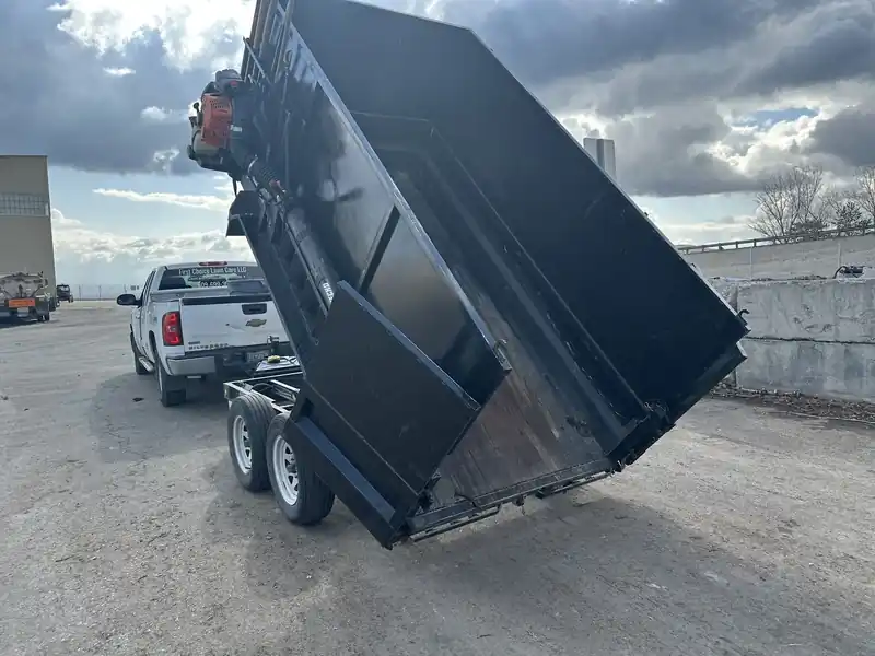 The First Choice dump trailer tipped up behind a pickup after a haul-away