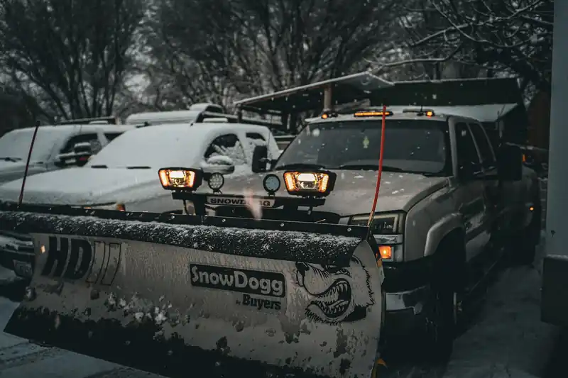 Two First Choice plow trucks with SnowDogg blades parked in the snow