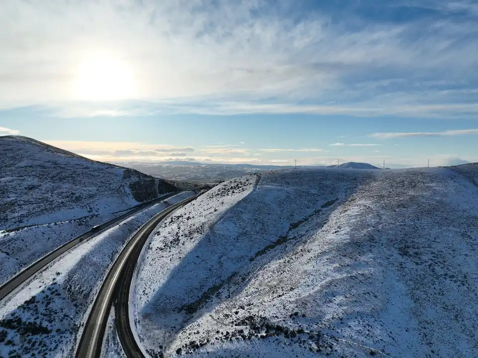 Drone view over snow-covered ridges and the highway running through the Yakima Valley hills